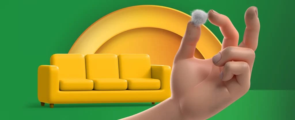 A hand holds a piece of lint that came from a yellow sofa. The image is green with a yellow half circle