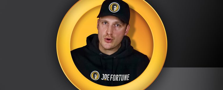 Joel Bergs wearing a Joe Fortune hoodie and baseball cap, peering through a yellow portal against a black background.