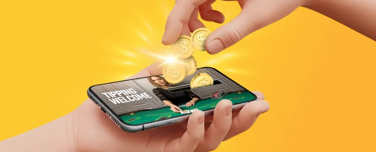 A hand holding a smartphone displaying a live dealer, while another hand drops gold coins into a slot on the phone screen on a yellow background.