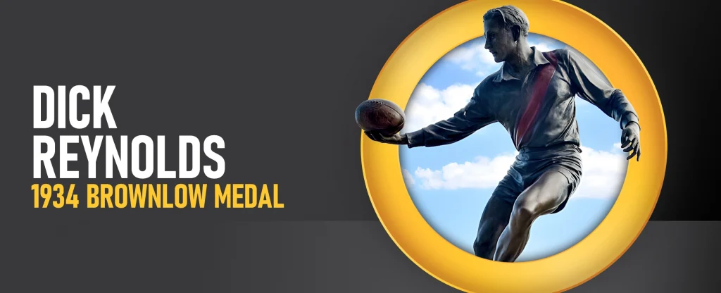 A bronze statue of AFL legend Dick Reynolds holding a football, with text reading “Dick Reynolds, 1934 Brownlow Medal,” displayed against a dark background with a yellow circular frame.